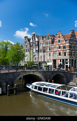 Tourist boat takes tour cruise group sightseeing on Dutch canals, Prinsengracht and Brouwersgracht , Amsterdam, Holland Stock Photo