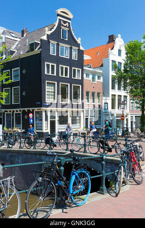 Canalside ornate gabled houses - Dutch gables - and bicycles Herengracht and Blauwburgwal in canal district, Jordaan, Amsterdam Stock Photo