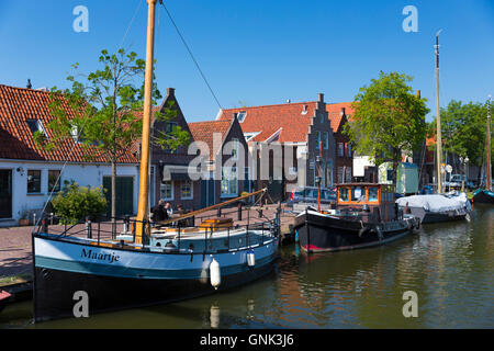 Sailing boats, sailboats, moored along canal waterway in front of traditional houses at  Edam in The Netherlands Stock Photo