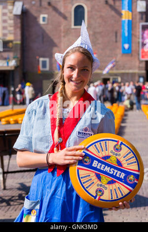 Dutch girl Kaasmeisje wearing traditional costume and Beemster Gouda cheese, Alkmaar cheese market, The Netherlands Stock Photo