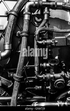 Fragment of modern technology. Details of engine pipelines. Black and white. Background. Stock Photo