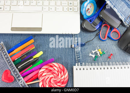 Creative learning objects on blue jeans for a new school year Stock Photo