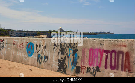 Graffiti on jetty by the Black Sea with St Vladimir's Cathedral on the horizon Sevastopol Crimea Stock Photo