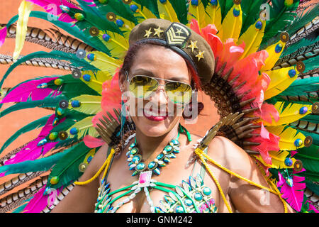 A festival performer in traditional costume parading at the Notting Hill carnival in West London Stock Photo