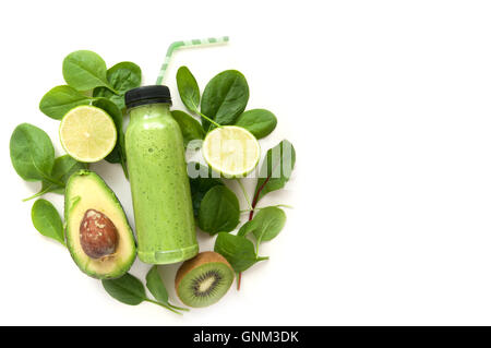 Green fruit and vegetable smoothie in a bottle surrounded by ingredients Stock Photo