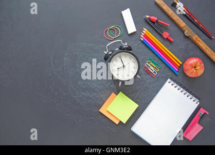 Stationery accessories on top of a chalkboard with space Stock Photo