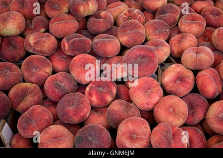 Boxes of flat peaches at a French market, Heathfield, Sussex, UK Stock Photo