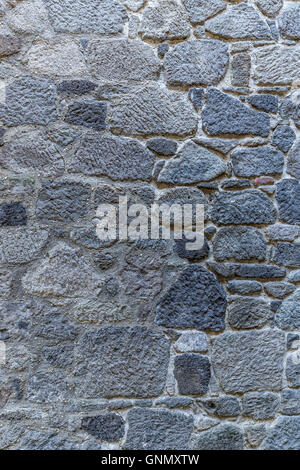 Uneven cracked real stone wall surface Stock Photo