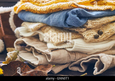 Stack of fall baby clothes on wooden background Stock Photo