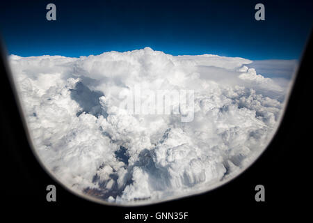 Aircraft. White clouds through the window during fly over clouds Stock Photo