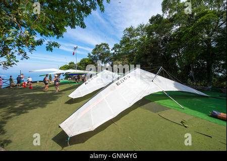 RIO DE JANEIRO - MARCH 22, 2016: Hang gliders take off in a production line from the ramp at Pedra Bonita, in the Tijuca Forest. Stock Photo