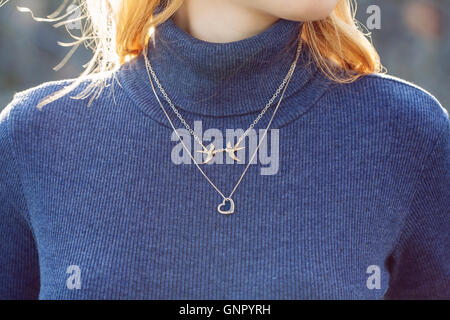 woman wearing a jewelry on her turtleneck Stock Photo