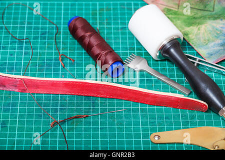 leather working - new belt, sewing tools and stitching chisel on self-healing mat Stock Photo