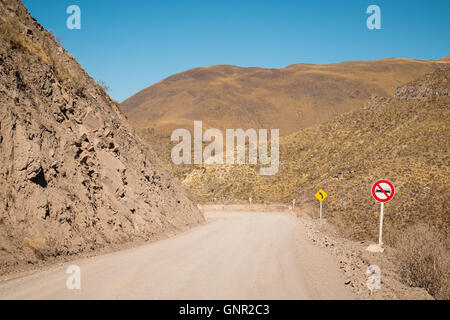 Warning signs on a steep road crossing an Andean moutain pass in Salta, Argentina Stock Photo