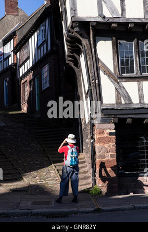 A tourist photographs Stepcote hill, one of the oldest surviving parts of Exeter, located in the West Quarter. According to Hosk Stock Photo