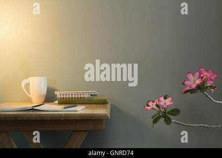 Open notebook on wooden desk with warm lighting Stock Photo