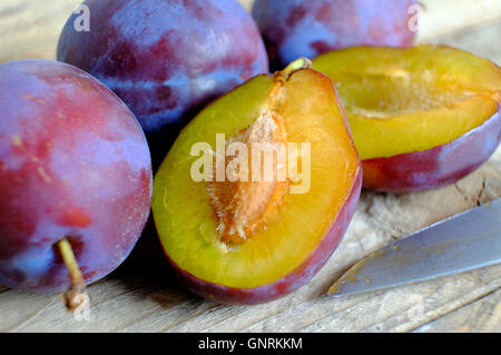 victoria plums on timber work surface Stock Photo