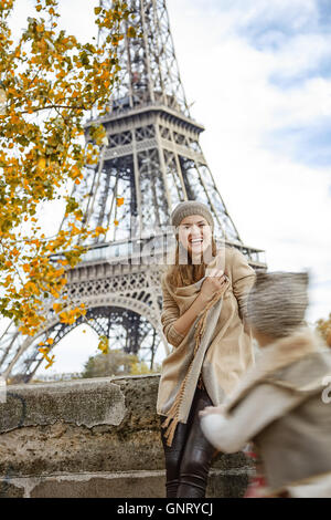 Autumn getaways in Paris with family. happy mother and daughter tourists on embankment in Paris, France playing outside Stock Photo