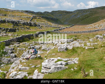 Walker resting in Watlowes valley, Ing Scar on the Pennine Way above Malham Cove, Yorkshire Dales National Park Stock Photo