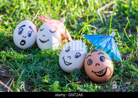 Funny eggs under umbrellas imitating happy mixed couple and indignant white couple Stock Photo