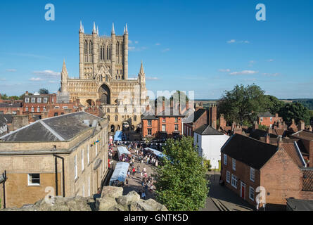 People browsing Castle Hill market stalls in historic City of Lincoln, UK, with Lincoln Cathedral in the background. Stock Photo