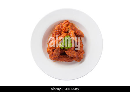 Top view of Korean style deep fried chicken wings mix with spicy barbecue sauce in ceramic dish isolated on white background Stock Photo