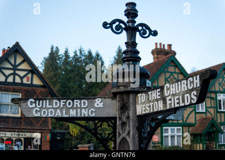 A wooden signpost in the village of Albury( showing directions to Guildford, Godalming, the Village Church), Surrey, UK Stock Photo