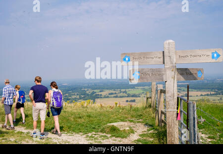 Country footpath signpost and people walking on South Downs Way trail in South Downs National Park countryside. Fulking Hill West Sussex England UK Stock Photo