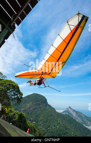 RIO DE JANEIRO - MARCH 22, 2016: A hang gliding instructor takes off with a passenger from the ramp at Pedra Bonita. Stock Photo