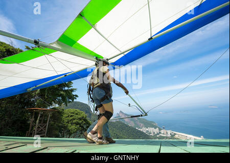 RIO DE JANEIRO - MARCH 22, 2016: A hang glider prepares to take off from the upper ramp at Pedra Bonita, in the Tijuca Forest. Stock Photo