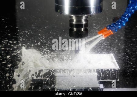 CNC machining center milling with cutting coolant. Stock Photo