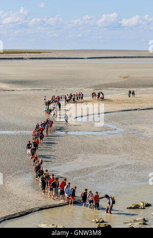A view across the sands at Mont-Saint-Michel with a school group of students