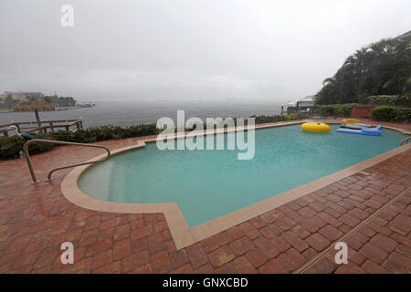 A swimming pool overlooking water in the rain Stock Photo