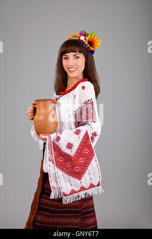 Attractive woman wears Ukrainian is holding a jug national dress Stock Photo