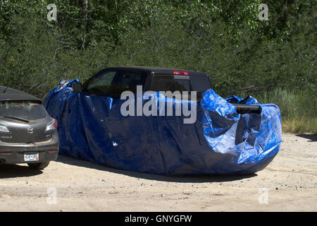 Vehicles protected with trapouline or wire to prevent marmots from damaging pipes etc. California. USA Stock Photo