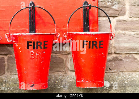 Two slightly battered hanging fire buckets Stock Photo