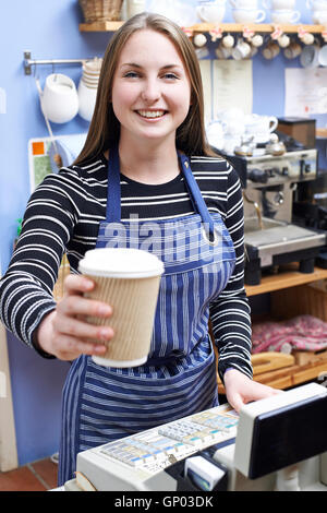 Waitress In Cafe Serving Customer With Takeaway Coffee Stock Photo