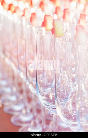 Group of empty cocktail glasses with hearth shape of watermelon on top preparing on table for party. Selective focus, shallow de Stock Photo