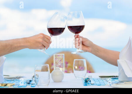 Couple drinking wine in romantic dinner on twighlight, closeup. Selective focus, shallow depth of field. Stock Photo