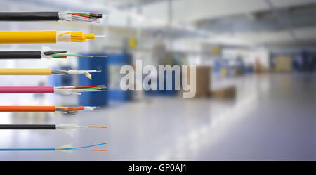 Collection of fiber optical cables on blurry production room background. Loose tubes with optical fibres and central strenght me Stock Photo