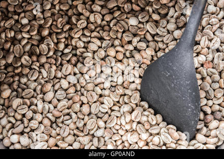 Green coffee beans with an old wooden bowl, ready to be roasted. Stock Photo
