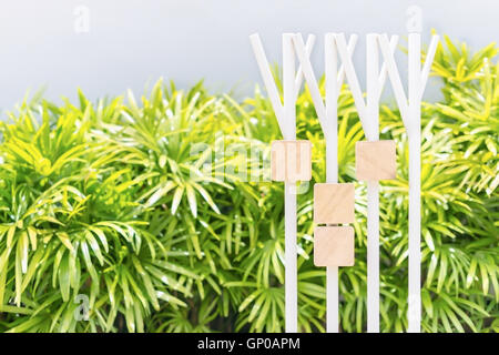 blank sandstone sign plates hang on steel columns in green garden background. Ready to fill text and symbol Stock Photo