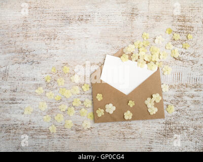 Kraft paper envelope with blank card and white viburnum flowers  on the rustic white painted background Stock Photo