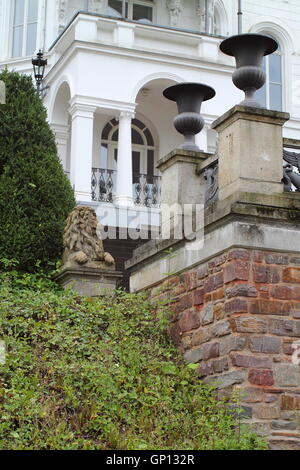 Fragment of old brick wall with bronze vases, white castle and lion sculpture Stock Photo