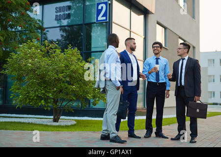 Four modern businessmen having outdoor discussion Stock Photo