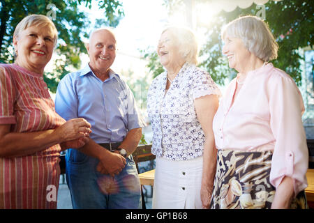 Group of cheerful seniors spending time in outdoor cafe Stock Photo