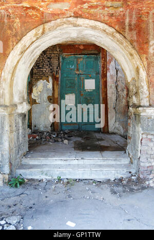 old door and the arch in the crumbling building Stock Photo