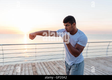 Handsome african american young man athlete boxing outdoors on sunrise Stock Photo