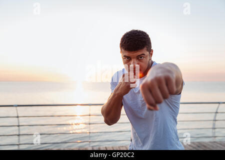 Handsome african american young man boxer practicing shadow boxing on sunrise Stock Photo