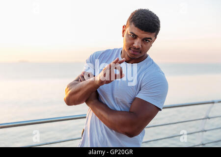 Confident african american young man standing and showing ok sign on pier Stock Photo